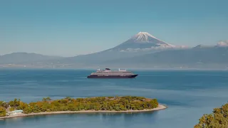 Luxury cruise ship EXPLORA III sailing past Mount Fuji in Japan