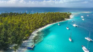 Luxury yachts anchored oin the San Blas Islands, surrounded by palm-fringed islets in Guna Yala, Panama
