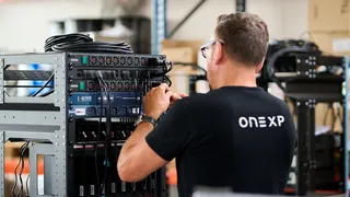 ONEXP technician installing hybrid connectivity equipment on a superyacht